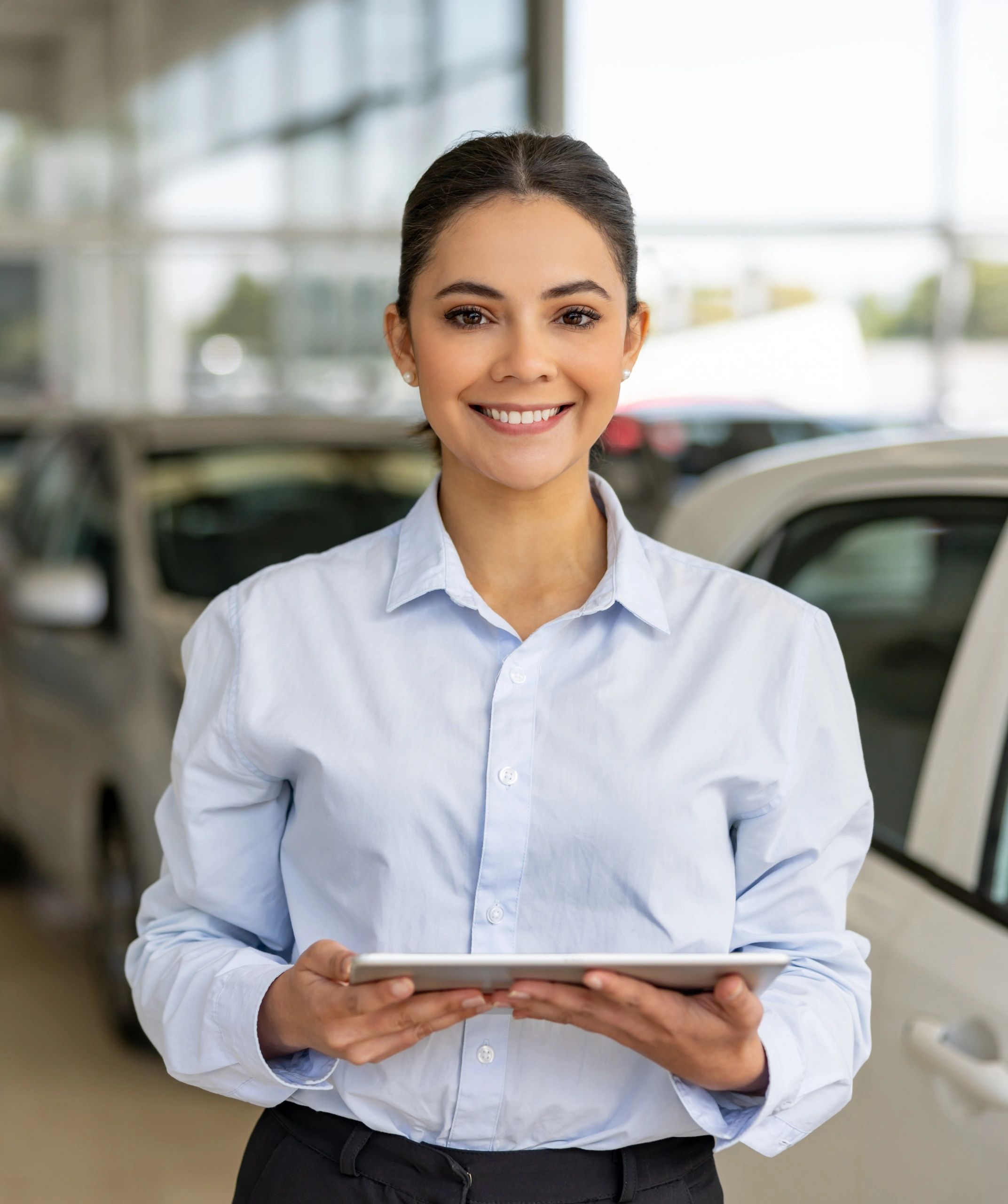 Automotive sales professional using a tablet at a dealership
