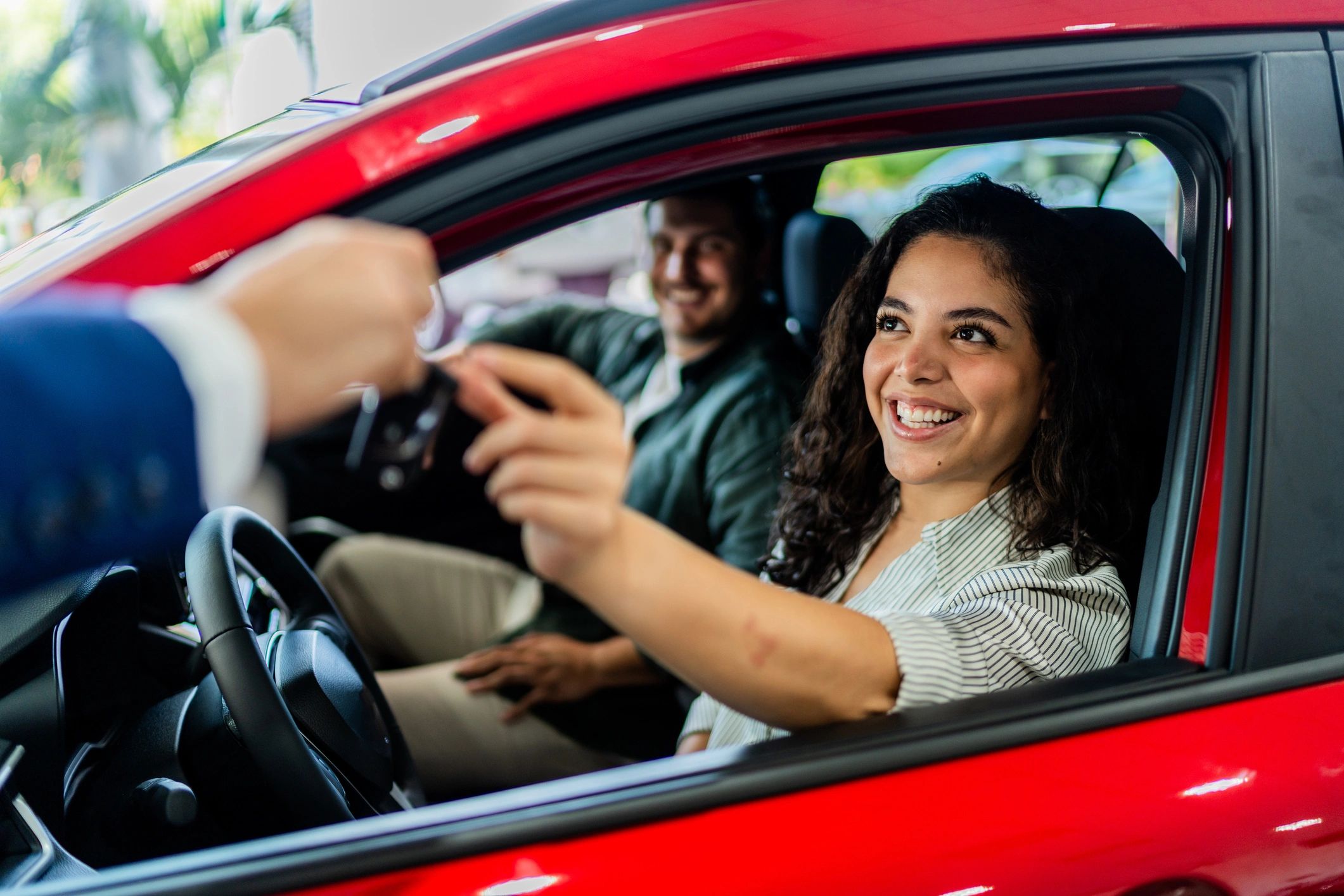 Happy customer receiving a car key at a dealership